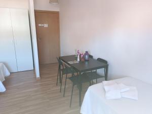 a room with a table and chairs and a bed at Pilgrim Rooms in Redondela