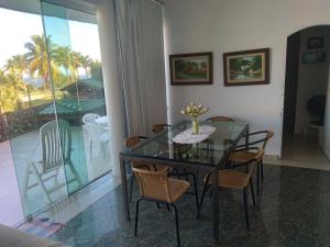 uma sala de jantar com uma mesa de vidro e cadeiras em Confortável, 1min da praia a pé em Niterói