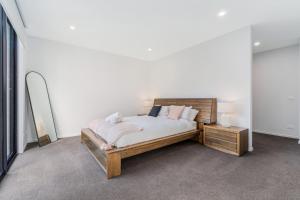 1 dormitorio con cama y espejo en Coastal Elegance, Torquay, en Torquay