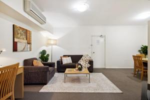 un soggiorno con un divano e un tavolo di Prized Perth Retreat 1BDR a Perth