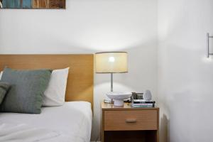 una camera con letto e lampada sul comodino di Prized Perth Retreat 1BDR a Perth Altre 19 foto