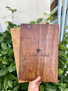 ręka trzymająca drewniany znak dla hotelu w obiekcie Solar Hotel w Ha Long