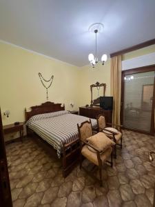 1 dormitorio con 1 cama, 1 silla y TV en Affittacamere da Elio e Renata, en Calvi dellʼ Umbria