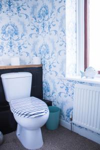 y baño con aseo y papel pintado de color azul y blanco. en Beach House in Berwick Upon Tweed - 2 Double Bedrooms, en Spittal