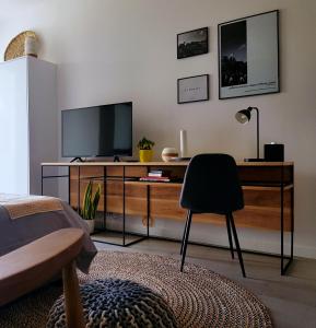 een woonkamer met een televisie en een stoel bij Studio 112 - Ebene Square in Ebene