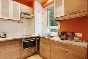 eine Küche mit Holzschränken und einem Fenster in der Unterkunft Cosy flat with garden -Neuilly-sur-Seine in Neuilly-sur-Seine