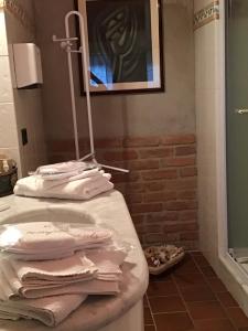 bagno con lavandino, doccia e asciugamani bianchi di Villa Moglietta ad Albaretto Della Torre