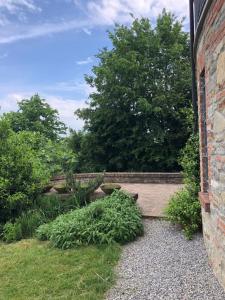 a brick wall next to a garden with plants at Villa Moglietta in Albaretto Della Torre 