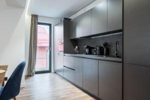 cocina con armarios grises, mesa y ventana en Oasis Haven I Radiant 1 BR apartment with terrace, en Voluntari