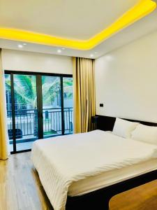a bedroom with a large bed and a balcony at Dahlia villa - Sonasea Vân Đồn Harbor city in Cái Rồng