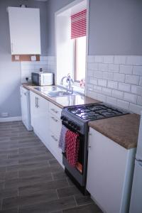 a kitchen with a stove and a sink at Beach House in Berwick Upon Tweed - 2 Double Bedrooms in Spittal