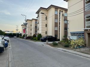 an empty street with cars parked in front of buildings at Bria Flats Condominium Azure in Cagayan de Oro