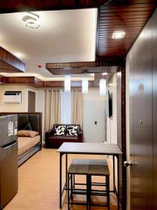 a kitchen and living room with a table and a couch at Bria Flats Condominium Azure in Cagayan de Oro +9 photos
