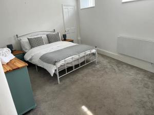 een slaapkamer met een bed in een witte kamer bij 2 bedroom cottage in Old Town in Swindon