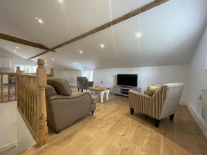 een woonkamer met een bank, een stoel en een televisie bij 2 bedroom cottage in Old Town in Swindon