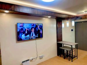 a room with a tv on a wall with a table at Bria Flats Condominium Azure in Cagayan de Oro