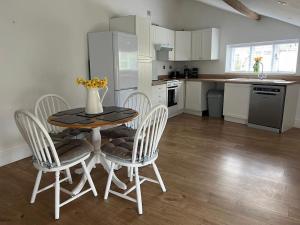 a kitchen with a table and chairs and a kitchen with white cabinets at 2 bedroom cottage in Old Town in Swindon