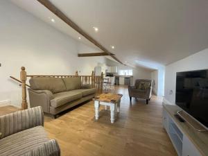 a living room with a couch and a table at 2 bedroom cottage in Old Town in Swindon