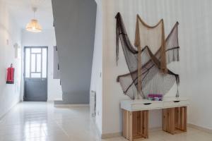a hallway with a white wall with a sculpture on it at BLife Martinya house - private rooms and apartments in Olhão +15 photos
