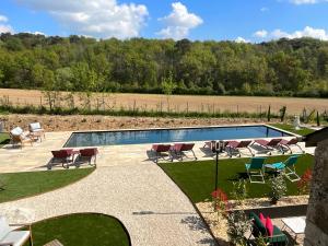 a swimming pool in a yard with chairs at Sans Souci Bed and Breakfast Luxe Heated Pool and Restaurant in Luzillé