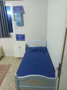 Le Bardo的住宿－Blue hostellerie，一间设有床铺的卧室,位于带标志的房间