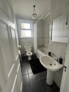 La salle de bains est pourvue d'un lavabo blanc et de toilettes. dans l'établissement Stunning 2-Bed Apartment in Shoreham-by-Sea, à Shoreham-by-Sea