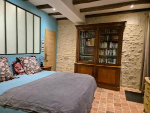 um quarto com uma cama e uma estante de livros em Les Granges de l'Épan em Joué-lés-Tours