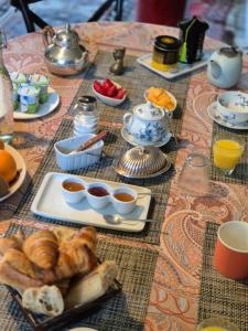 a table with a breakfast of croissants and orange juice at Les Granges de l'Épan in Joué-lès-Tours +55 photos