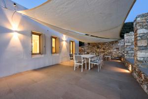 a dining room with a table and chairs under a tent at Stunning new villa with great pool area, magnificent panoramic sea view - Paros in Angairiá