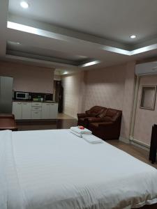 芭達雅南區的住宿－Del Mar Rooms，卧室配有一张白色的大床和一张沙发。