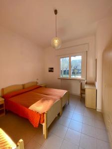 um quarto com uma cama grande e uma janela em Abruzzi 35 em Cervia