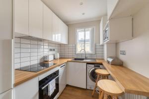 a kitchen with white appliances and wooden counter tops at Modern and Bright 1 Bed Apartment, Tower Bridge in London