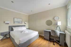 a bedroom with a bed and a desk and a chair at Modern and Bright 1 Bed Apartment, Tower Bridge in London