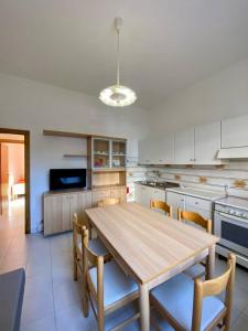 uma grande cozinha com uma mesa de madeira e cadeiras em Abruzzi 35 em Cervia