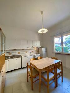 eine Küche mit einem Holztisch und Stühlen in der Unterkunft Abruzzi 35 in Cervia