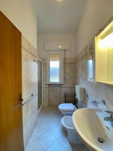 ein Badezimmer mit 2 WCs und einem Waschbecken in der Unterkunft Abruzzi 35 in Cervia