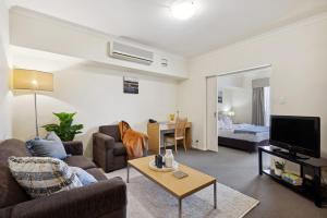 a living room with a couch and a tv at Perth City Corporate 1BRD in Perth