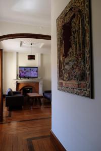 a living room with a fireplace and a painting on the wall at Yellow Inn Aveiro in Aveiro
