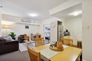 cocina y sala de estar con mesa y sillas en Perth City Corporate 1BRD, en Perth