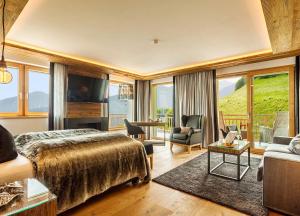 1 dormitorio con 1 cama grande y sala de estar en Hotel Watles, en Malles Venosta