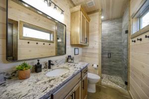 a bathroom with a sink and a toilet and a mirror at Morning Roast Cabin in Broken Bow