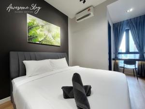 1 dormitorio con 1 cama blanca y 2 toallas negras. en Sunway Velocity Two By Awesomestay, en Kuala Lumpur