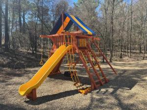 a playground equipment with a slide and a slideintend at Morning Roast Cabin in Broken Bow +26 photos