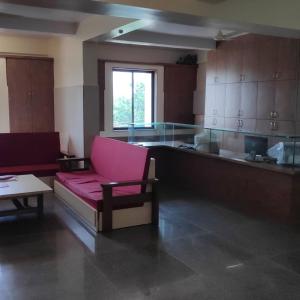un soggiorno con divano rosa e tavolo di Kamala Shanti Palace, Jule a Solapur