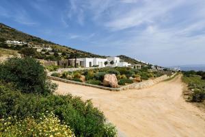 a dirt road in front of a house on a hill at Stunning new villa with great pool area, magnificent panoramic sea view - Paros in Angairiá