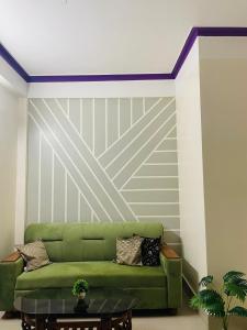 zieloną kanapę w pokoju ze ścianą w obiekcie Renade Leisure Stay w mieście Agartala