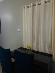 Zimmer mit einem Tisch und einem Fenster mit Vorhängen in der Unterkunft Renade Leisure Stay in Agartala