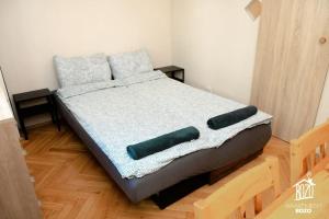 a bed with two pillows on it in a room at Otthonos társasházi lakás a Váci út mellett in Budapest