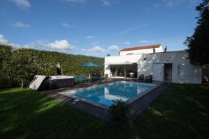 a backyard with a swimming pool and a house at Quinta do Ferreiro in Ponta Delgada