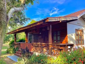 una baita di tronchi con un portico e un albero di เชียงคานเรือนไม้ รีสอร์ท a Amphoe Chiang Khan